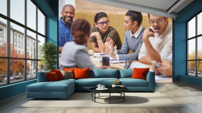 Around the boardroom table. Cropped shot of a large group of corporate businesspeople sitting around a table in the boardroom during a meeting. Wall mural