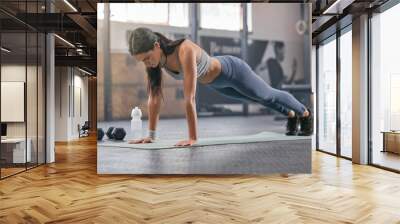 Gym, woman and workout with push ups for muscle or body building for wellness, wellbeing and self care. Female person, training centre and serious with exercise or training for fitness and strength Wall mural