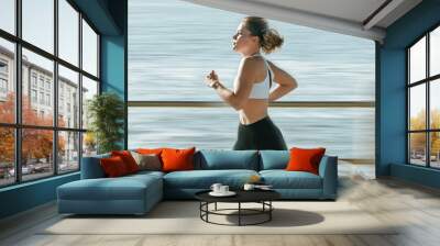 Woman, fitness and speed running by beach on mockup for exercise, workout or cardio routine. Active female runner in fast run, sprint or race by the ocean coast for healthy exercising or wellness Wall mural