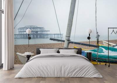 Brighton, United Kingdom, February 2019: West Pier, two fires in March and May 2003 left little of the original structure; pebble beach and blue fishing boat. Wall mural