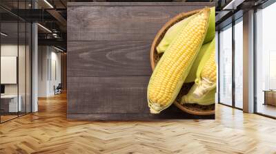 Fresh organic yellow sweet corn on wooden table. Top view Wall mural