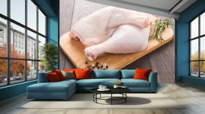 Raw chicken leg on cutting board on wood table Wall mural