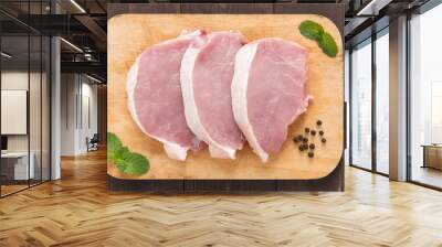 Raw pork on cutting board on wooden background. Wall mural