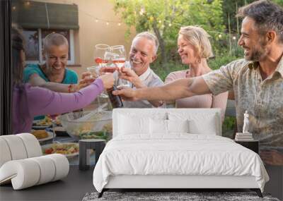 Happy friends laughing with big smile and toasting in a summer outside diner. Smiling people eating at house patio. Smiles, cheerfulness concept. Wall mural