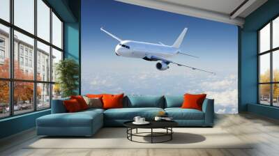 airplane in the sky, over the cloudy sky Wall mural