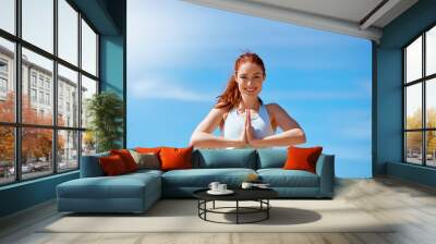 All aspects of my life are harmonious and balanced. Shot of a young woman practicing her yoga routine at the beach. Wall mural