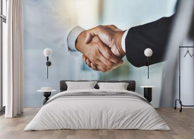 Clinical meets corporate. Cropped shot of a doctor shaking hands with a businessman in a hospital. Wall mural