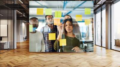 Collaborating their way to a successful campaign. Shot of colleagues having a brainstorming session with sticky notes at work. Wall mural