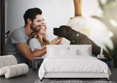 He brings joy and laughter into our lives. Shot of a couple and their pet relaxing at home. Wall mural