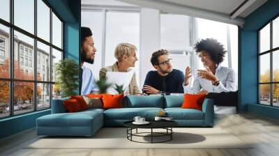 I need everyone to give me their best ideas. Shot of a group of businesspeople sitting together in a meeting. Wall mural