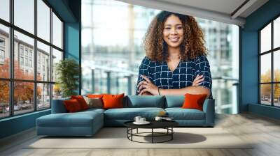 My hard work has gotten me to the top. Cropped portrait of an attractive young businesswoman standing with her arms folded in a modern office. Wall mural