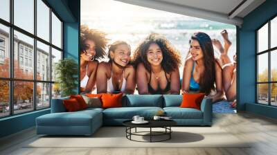 Nothing inspires happiness like a beachy day with best friends. Portrait of a group of happy young women relaxing together at the beach. Wall mural