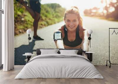 Preparing her muscles for an amazing workout. Shot of a young woman stretching before her run outdoors. Wall mural