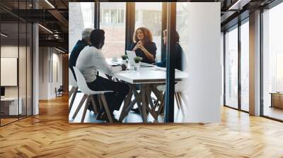 Running through some of their big ideas together. Shot of a group of businesspeople having a boardroom meeting in an office. Wall mural