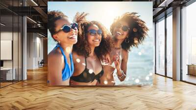 The beach sure is a beautiful place to be. Shot of a group of happy young women having fun together at the beach. Wall mural