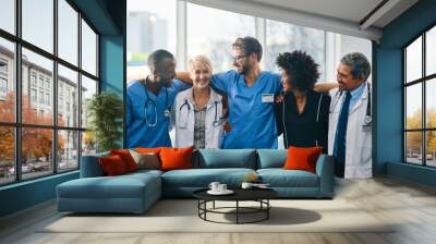 Together well take care of you. Portrait of a diverse team of doctors standing together in a hospital. Wall mural