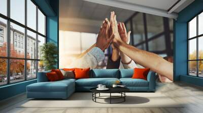 We always win. Shot of a group of colleagues giving each other a high five. Wall mural