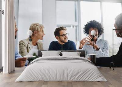 With the help of the whole team, anything is possible. Shot of a group of businesspeople sitting together in a meeting. Wall mural