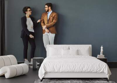 You gain so much from mingling. Shot of two designers having a conversation while leaning against a wall. Wall mural