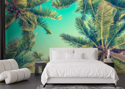 Looking up at blue sky and palm trees, view from below, vintage style, tropical beach and summer background, travel concept Wall mural