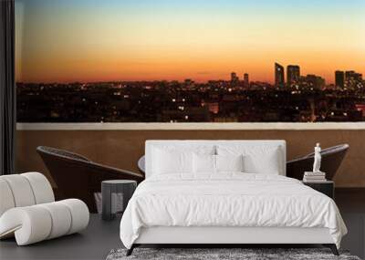 Table and chairs on a terrace, view on a city at night Wall mural