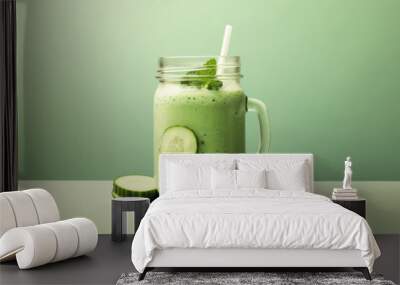 Blended green cucumber smoothie drink, solid green background. Refreshing and inviting. Summer drinks. Cucumber garnish. Studio photography, product shot. Wall mural