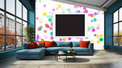 Touchpad with blank screen on colorful confetti background. Tablet computer on white background with confetti. Flat lay. Top view Wall mural