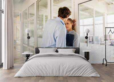 Formal man and woman flirting while standing in hall of office building having adultery Wall mural