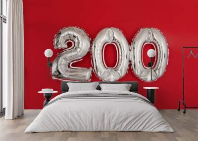 From above of silver shiny balloons demonstrating number 200 two hundred on red background with scattered glitter Wall mural