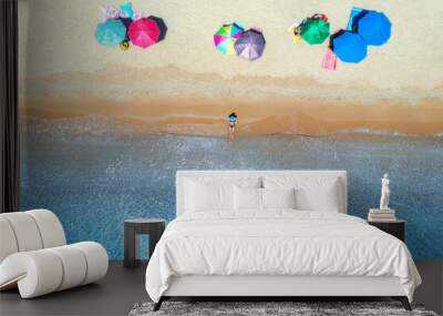 Aerial view of a lying woman on sandy beach, colorful umbrellas and blue sea at sunny day in summer. Tropical landscape with girl, clear water, waves, sea coast. Top view. Sardinia island, Italy	 Wall mural