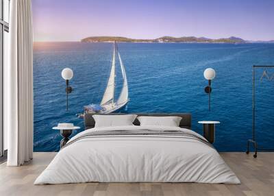 Aerial view of beautiful white sailboat in blue sea at bright sunny summer evening. Adriatic sea in Croatia. Landscape with yacht, mountains, transparent blue water, sky at sunset. Top view of boat Wall mural