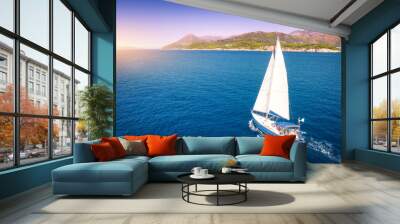 Aerial view of beautiful white sailboat in blue sea at bright sunny summer evening. Adriatic sea in Croatia. Landscape with yacht, mountains, transparent blue water, sky at sunset. Top view of boat Wall mural