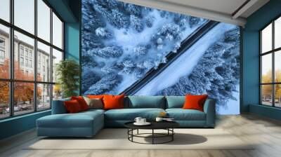 Aerial view of mountain road in fairy forest in snow in winter in blue hour. Top view from drone of highway, snowy pine trees at dusk. Beautiful rural road in woods in twilight. Travel in Slovenia Wall mural