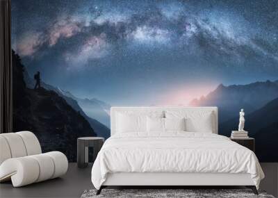 Arched Milky Way, woman and mountains at night. Silhouette of standing girl on the mountain peak, mountains in low clouds and starry sky in Nepal. Space landscape with bright milky way arch. Travel Wall mural