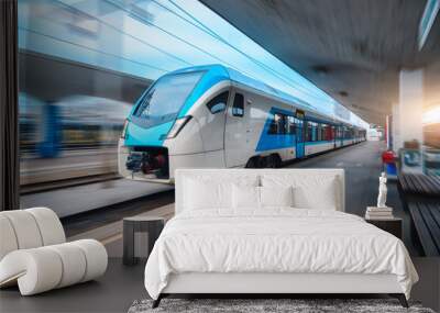 Blue high speed train in motion on the railway station at sunset. Fast modern intercity train and blurred background. Railway platform. Railroad in Slovenia. Commercial and passenger transportation Wall mural