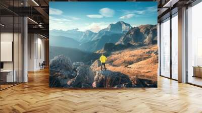 Man on the mountain peak and beautiful high rocks at colorful sunset in autumn in Dolomites, Italy. Landscape with sporty guy on the stone, cliffs, orange grass, blue sky in fall. Trekking and hiking	 Wall mural