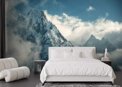 Manaslu mountain with snowy peak in clouds in sunny bright day in Nepal. Landscape with high snow covered rocks and blue cloudy sky. Beautiful nature. Fairy scenery. Aerial view of Himalayan mountains Wall mural