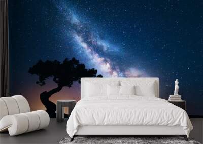 Milky Way with alone old crooked tree on the hill. Colorful night landscape with bright milky way, starry sky and tree in summer. Space background. Amazing astrophotography. Beautiful universe. Travel Wall mural