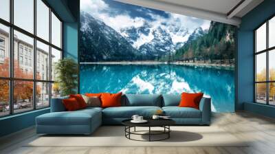 Mountain lake with perfect reflection at sunny day in autumn. Dolomites, Italy. Beautiful landscape with azure water, trees, snowy mountains in clouds, blue sky in fall.  Snow covered rocks. Nature Wall mural