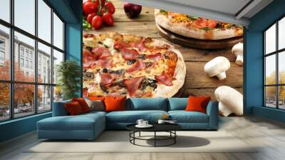 due pizze con prosciutto mozzarella pomodori su sfondo di legno rustico Wall mural