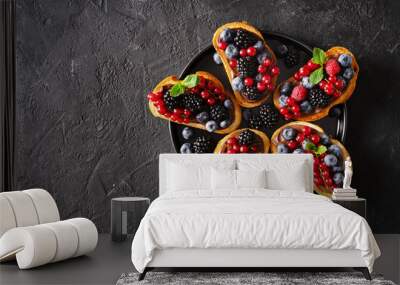 Bread toast with chocolate paste and berries on black background Wall mural