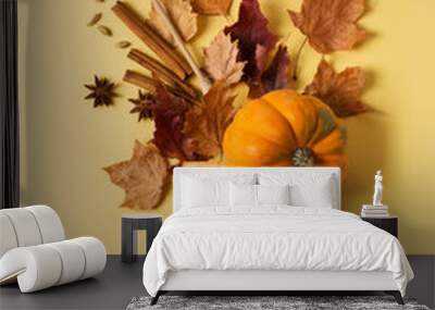 Crative flat lay with brush, leaf, spice and pumpkin on yellow background Wall mural