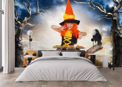  Halloween.The little witch,the child reads the spell in the sorcerer book. Wall mural