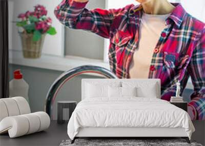 Tired woman washes plate in kitchen Wall mural