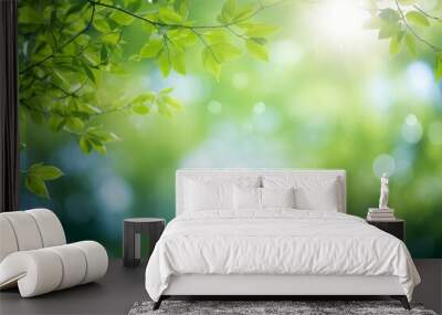 Blurred bokeh background of fresh green spring, summer foliage of tree leaves with blue sky and sun flare Wall mural