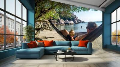 young man relaxing in hammock on the beach Wall mural