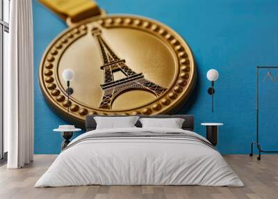 French gold medal with Eiffel Tower on it, isolated on blue. Travel landmark, copy space Wall mural