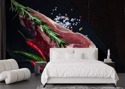 Fresh Raw Beef bone rib roughly choppid on a black stone plate. Wall mural