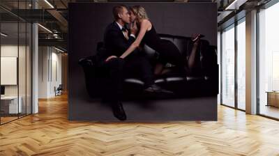 Beautiful couple in love kissing sitting on the couch Wall mural