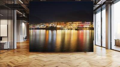 Night view of Hersonissos. Reflection of city lighting in the water. Wall mural